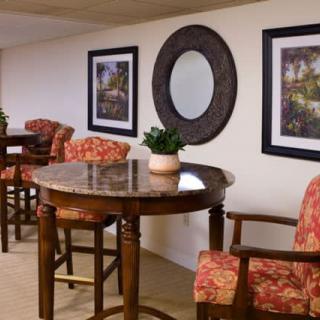 A cozy seating area with a round table, chairs, and decorative art on the walls.