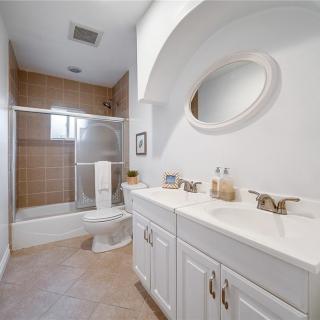A modern bathroom with double sinks and a bathtub.