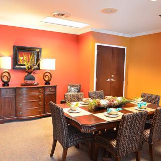 A warmly decorated dining room with a set table and vibrant walls.
