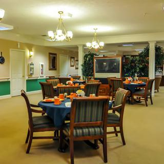 A well-lit dining area with neatly arranged tables and chairs.