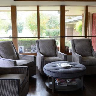 A cozy living room with comfortable chairs and a central coffee table.