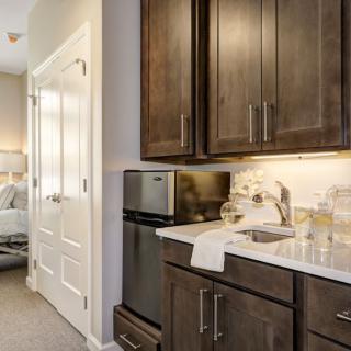 A modern kitchen with dark cabinets and stainless steel appliances.