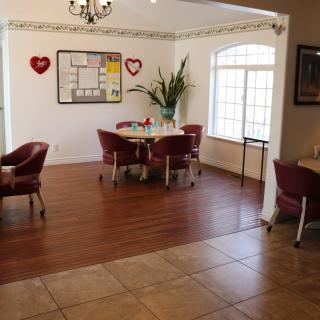 A cozy dining area featuring a set of tables and chairs, adorned with heart-themed decorations and a bulletin board on the wall.