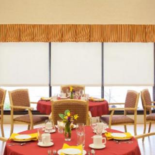 A well-set dining area with tables and chairs, featuring elegant tableware and decor.