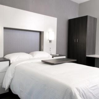 A modern, minimalist bedroom with neutral tones and sleek furniture.