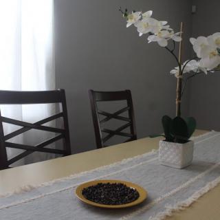 A dining table with a decorative orchid and a plate of berries.