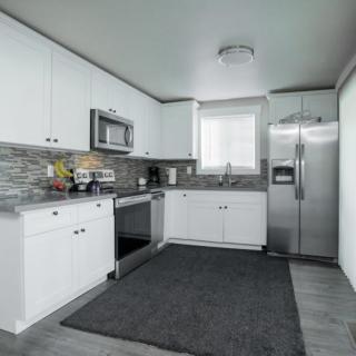 A modern kitchen with white cabinetry and stainless steel appliances.