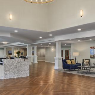 A spacious and modern lobby with a reception desk and comfortable seating area.