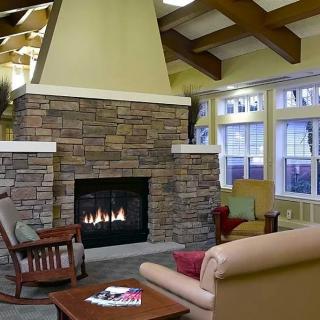 A cozy living room with a stone fireplace and comfortable seating.