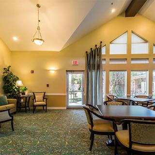 A cozy living room with comfortable seating, a table, and large windows allowing natural light.