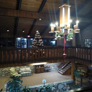 A welcoming interior lobby featuring a Christmas tree, wooden architecture, and warm lighting.