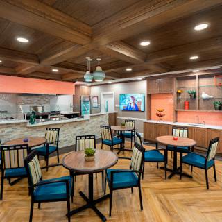 A modern dining area featuring a cozy layout with wooden accents and a kitchen view.