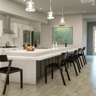 A modern kitchen featuring an open-plan layout with a large island countertop and sleek bar stools.