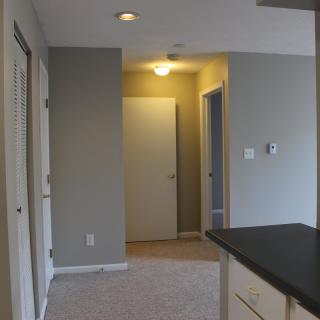 A modern apartment hallway with neutral colors and closed doors.