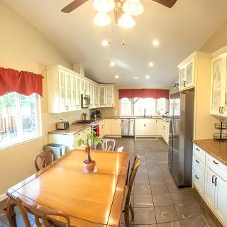A spacious kitchen with a wooden dining table and modern amenities.