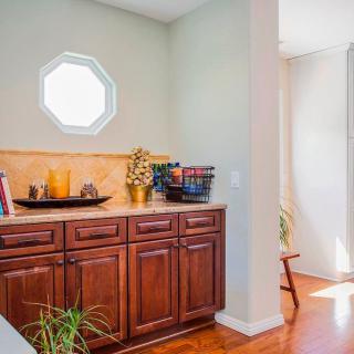 A cozy home interior with wooden cabinets and a small window letting in sunlight.