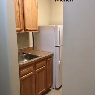 Compact kitchen space with wooden cabinets and appliances.