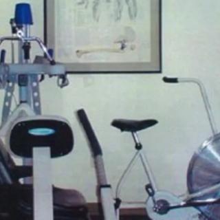 A home gym setup with a stationary bike and other exercise equipment.