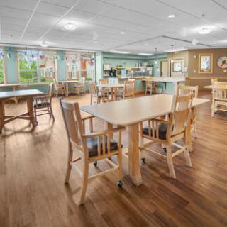 A spacious and well-lit dining area featuring wooden furniture and ample natural light.