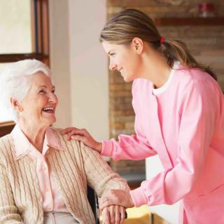 A nurse providing care and companionship to an elderly woman at home.
