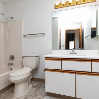 A modern bathroom with a toilet, sink, and bathtub.