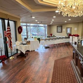 A decorated banquet hall with tables, a chandelier, and an American flag.