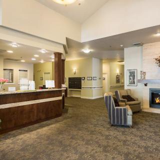 A spacious and well-lit lobby with a reception desk and comfortable seating area.