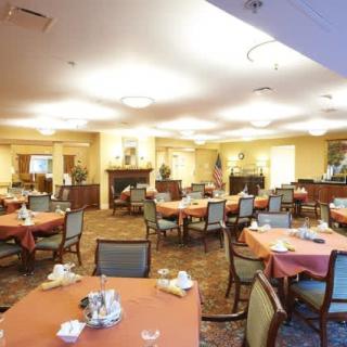 An empty dining room with neatly arranged tables and chairs.