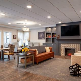 A modern and cozy living room featuring a comfortable sofa, large TV, and stylish fireplace.