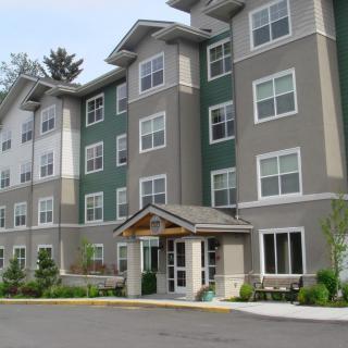 A modern apartment building with multiple floors and a welcoming entrance.