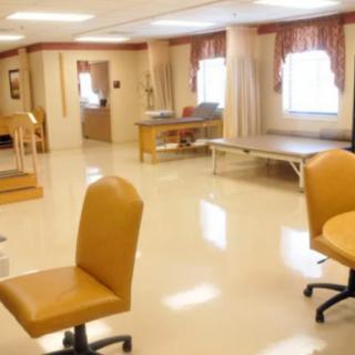 A clean and organized therapy room in a medical facility with chairs and tables.