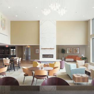 A spacious, modern lobby with comfortable seating and a central fireplace.
