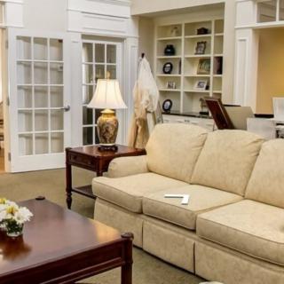 A cozy living room with a beige sofa, wooden coffee table, and bookshelves.