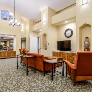 A spacious living room with comfortable seating, a television, and elegant lighting.