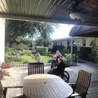A serene outdoor space at a care facility with seniors enjoying the garden.