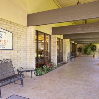 The entryway of a building featuring benches, signage, and a covered walkway.