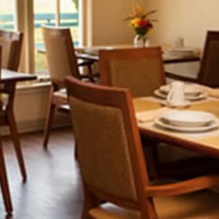 A cozy dining area with neatly set tables and chairs, showcasing a warm interior decor.