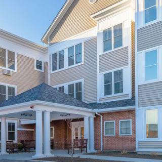 A residential building with a covered entrance and multiple windows.