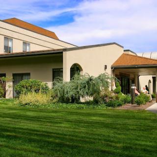 A beautifully landscaped residential building surrounded by lush green grass.