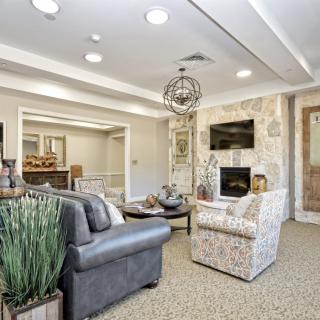 A modern living room with comfortable furniture, featuring a fireplace and a television.