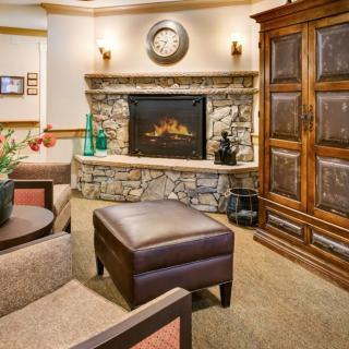 A cozy living room with a stone fireplace and comfortable seating.