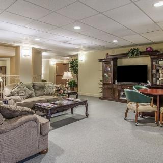 A cozy living room area featuring a sofa, television, and wooden furniture.