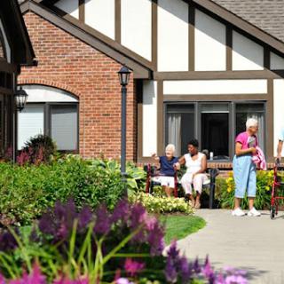 Seniors enjoy a sunny day in the garden of their residential facility.