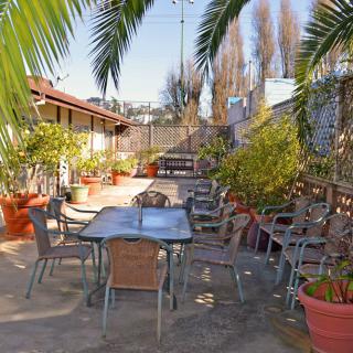 A sunny outdoor patio with tables, chairs, and potted plants.