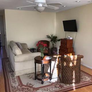 A cozy living room with a sofa, television, and various decor elements.