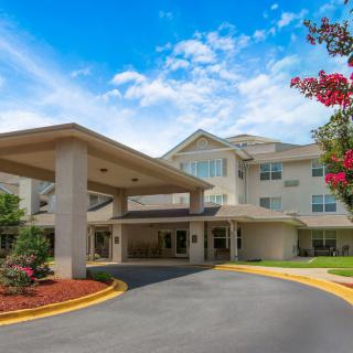 A welcoming entrance with landscaped surroundings under a bright blue sky.