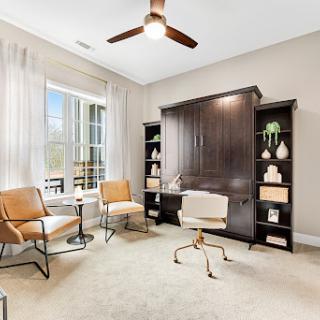 A beautifully designed home office featuring modern furniture and ample natural light.