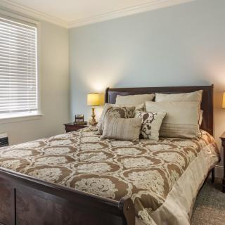 A cozy bedroom with elegant bedding and warm lighting.