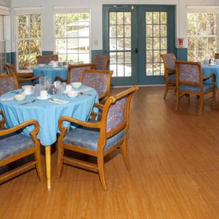 A well-arranged dining area with tables and chairs, featuring blue tablecloths.