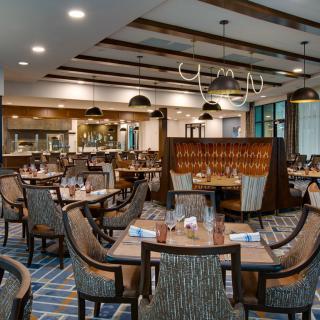 A modern and elegantly decorated restaurant interior with neatly arranged tables and chairs.